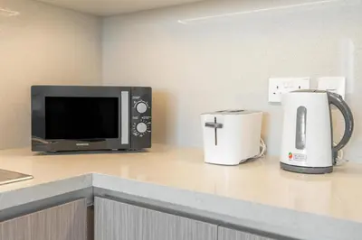 a microwave and a coffee maker on a counter at Lux BnB The Grand Creek Harbor Views in Dubai