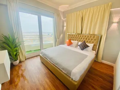 a bedroom with a bed with a large window at Manchester Regency - 2BR Apartment in Dubai Marina in Dubai