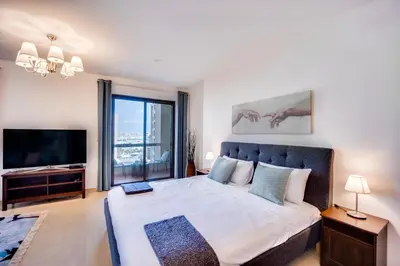 a bedroom with a large bed and a television at Big sea view studio in JBR in Dubai