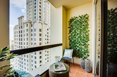 a balcony with a table and a ivy wall at Big sea view studio in JBR in Dubai