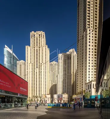 a city with tall buildings and people walking in the street at Big sea view studio in JBR in Dubai