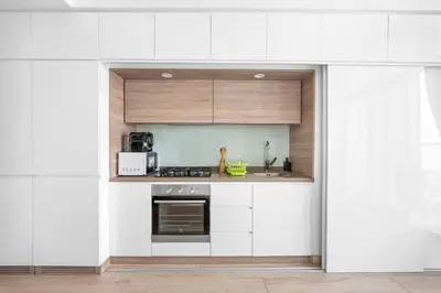 a kitchen with white cabinets and a microwave at ALiving Cozy Studio with Canal View I Studio One, Dubai Marina in Dubai