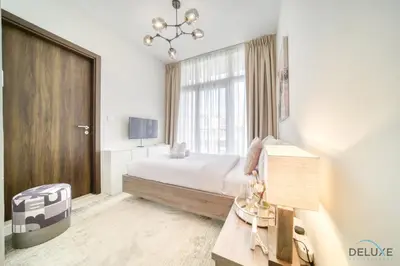 a bedroom with a bed and a large window at Alluring 3BR Townhouse at DAMAC Hills 2, Dubailand by Deluxe Holiday Homes in Dubai