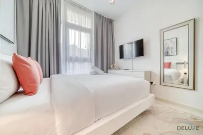 a white bedroom with a large bed and a mirror at Alluring 3BR Townhouse at DAMAC Hills 2, Dubailand by Deluxe Holiday Homes in Dubai