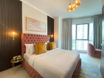 a hotel room with a large bed with yellow pillows at Durrani Homes - The Residences 5BR Besides Dubai Mall with Burjkhalifa and Fountain view in Dubai