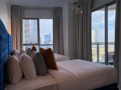 a hotel room with a bed with pillows and a window at Durrani Homes - The Residences 5BR Besides Dubai Mall with Burjkhalifa and Fountain view in Dubai