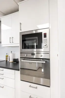 a stainless steel oven in a kitchen with white cabinets at Deluxe Retreat In JBR - Million Dollar View - Balcony in Dubai