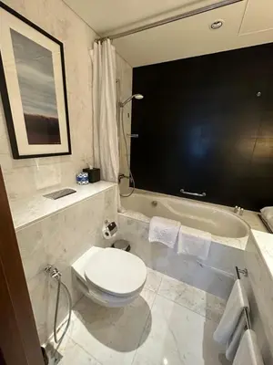 a bathroom with a toilet and a bath tub at Fashion Avenue Dubai Mall Highest Floor Burj Khalifa View Residence- Formerly Address Dubai Mall in Dubai
