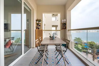 a dining room with a table and a large window at Frank Porter - Al Nabat in Dubai