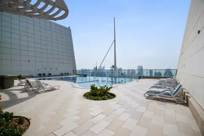 a pool on the roof of a building with lounge chairs at Chic JLT Studio, Lake View, Pool, Metro Access in Dubai