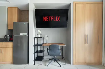a kitchen with a desk and a refrigerator and a chair at Chic JLT Studio, Lake View, Pool, Metro Access in Dubai