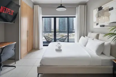 a bedroom with a large bed and a large window at Chic JLT Studio, Lake View, Pool, Metro Access in Dubai