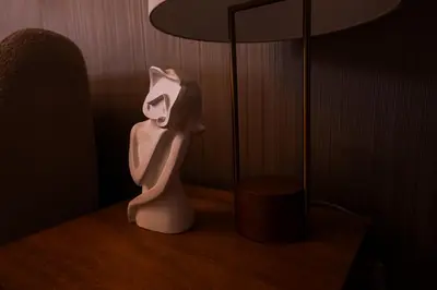 a white statue sitting on a table next to a lamp at Majestay - Luxury Living in Dubai
