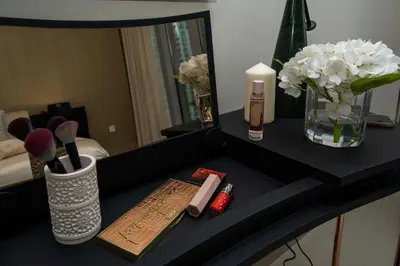 a black table with cosmetics and flowers on it at Majestay - Luxury Living in Dubai