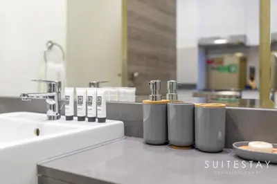 a kitchen counter with four silver trash cans and a sink at Prestigious Studio With High Quality Interiors in Dubai