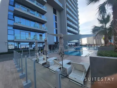 a group of chairs and umbrellas in front of a building at Prestigious Studio With High Quality Interiors in Dubai