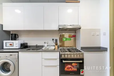 a kitchen with white cabinets and a stove top oven at Prestigious Studio With High Quality Interiors in Dubai