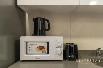 a microwave on a kitchen counter with a bowl of food at Prestigious Studio With High Quality Interiors in Dubai