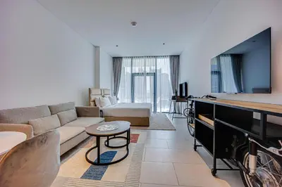 a living room with a couch and a flat screen tv at Stylish studio in Marquise Square Tower in Dubai