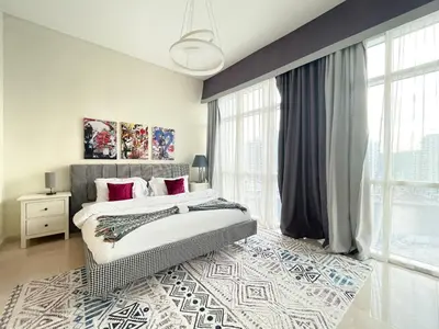 a bedroom with a bed and a large window at Trophy Stays - Vibrant Work-Friendly Studio in Business bay in Dubai