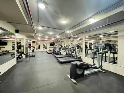 a gym with a row of treadmills and machines at Trophy Stays - Vibrant Work-Friendly Studio in Business bay in Dubai