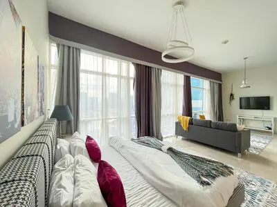 a bedroom with two beds and a couch at Trophy Stays - Vibrant Work-Friendly Studio in Business bay in Dubai