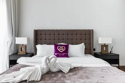 a bed with a purple pillow on top of it at SIMPLY COMFORT in J ONE Tower in Dubai