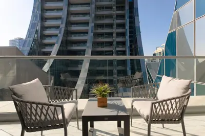 a patio with two chairs and a table and a building at SIMPLY COMFORT in J ONE Tower in Dubai