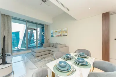 a living room with a table and chairs and a couch at SIMPLY COMFORT in J ONE Tower in Dubai