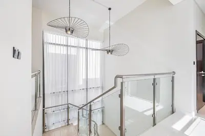 a staircase with two pendant lights and a window at Daniels Golf Course 5BR Villa with Private Pool in Dubai