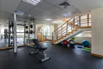 a gym with a treadmill and weights and a stair at GuestReady - Oliver Twist in Dubai