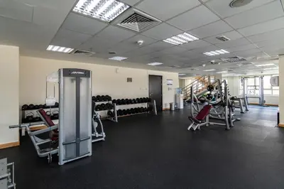 a gym with treadmills and machines in a room at GuestReady - Oliver Twist in Dubai