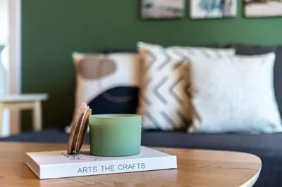 a green cup on a book on a table at GuestReady - Oliver Twist in Dubai