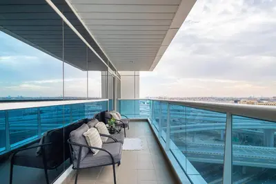 a balcony with two chairs on the top of a building at Frank Porter - Opal Tower in Dubai