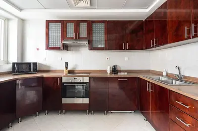 a kitchen with wooden cabinets and a sink and a microwave at Frank Porter - Opal Tower in Dubai