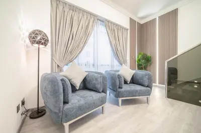 a living room with two chairs and a television at Boutique Luxury Living near Palm Jumeirah in Dubai