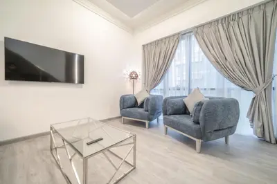 a living room with two chairs and a tv at Boutique Luxury Living near Palm Jumeirah in Dubai