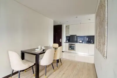 a kitchen and dining room with a black table and white chairs at Welcome Home at The Address Marina 1BR in Dubai