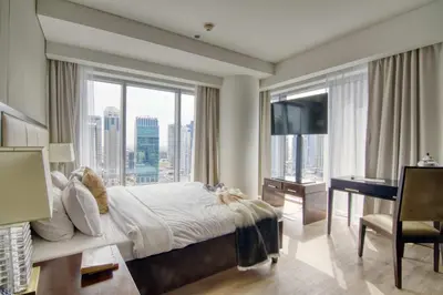 a bedroom with a bed and a desk and windows at Welcome Home at The Address Marina 1BR in Dubai
