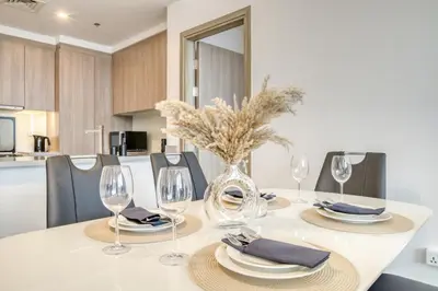a dining table with glasses and a vase on it at Stella Maris, Dubai Marina - Mint Stay in Dubai