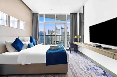 a hotel room with a large bed and a flat screen tv at Vacay Lettings - Waterfront Studio with great Dubai Canal view in Dubai
