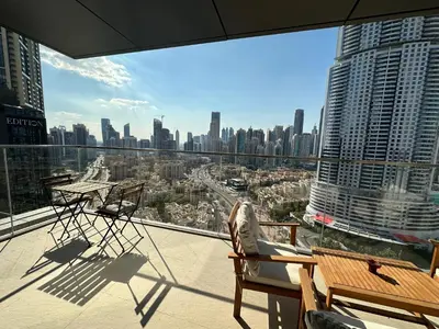 a balcony with chairs and tables and a view of a city at Holidays R Us Royal View in Dubai