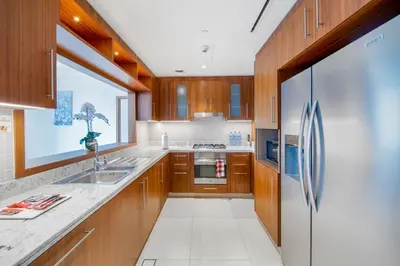 a kitchen with wooden cabinets and a stainless steel refrigerator at Holidays R Us Royal View in Dubai
