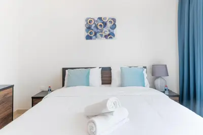 a bedroom with a white bed with towels on it at Holidays R Us Royal View in Dubai