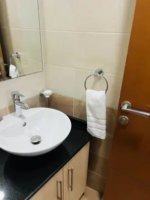 a bathroom with a white sink and a mirror at Ocean Heights - Spacious 1 Bedroom Apartment with Sea View, Gym & Free Parking in Dubai