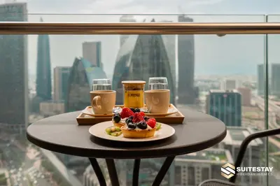 a table with a plate of food and two glasses of beer at OSTAY -Address Dubai Mall - The Residence in Dubai