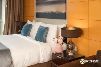 a bedroom with a bed and a table with a lamp at OSTAY -Address Dubai Mall - The Residence in Dubai