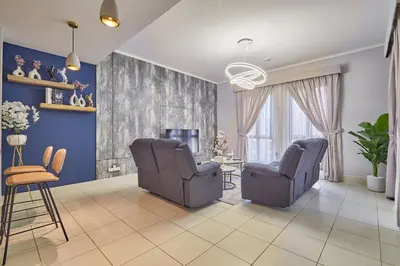 a living room with two chairs and a table at Golden homes Burj khalifa view Yansoon 1BR heart & Soul old town Beside Dubai mall Burjh Khalifa in Dubai