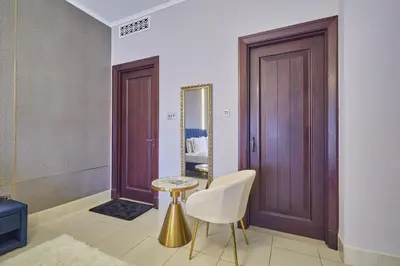 a room with a door and a chair and a mirror at Golden homes Burj khalifa view Yansoon 1BR heart & Soul old town Beside Dubai mall Burjh Khalifa in Dubai