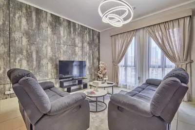 a living room with two chairs and a television at Golden homes Burj khalifa view Yansoon 1BR heart & Soul old town Beside Dubai mall Burjh Khalifa in Dubai
